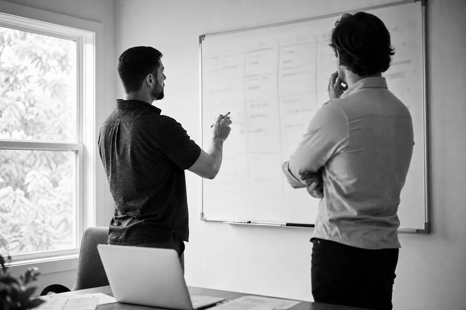 Small land investing team at a whiteboard comparing monthly tool costs